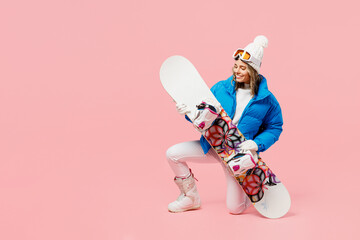 Full body snowboarder fun woman wear blue suit goggles mask hat ski padded jacket kneeling hol...