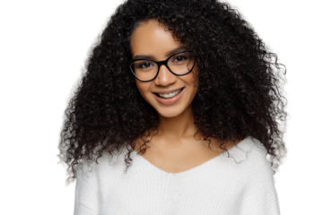 Headshot of curly haired smiling woman has healthy dark skin, Afro hairstyle, smiles gently at camera, weras optical glasses and white jumper enjoys spare time with friends isolated on grey background