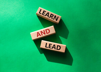 Learn and lead symbol. Concept words 'Learn and lead' on wooden blocks. Beautiful green background. Business and Learn and lead concept. Copy space.