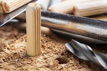 drill bit makes hole in wooden oak board for wooden dowel.