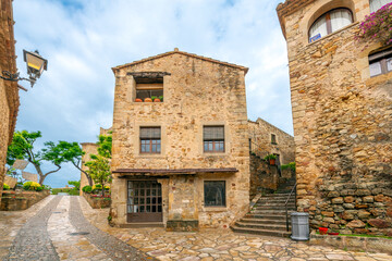 Fototapeta na wymiar The wet streets of the medieval village of Pals, Spain after a summer rainstorm along the Costa Brava coast of the Catalonian region. 