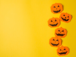Halloween concept. Paper origami pumpkin on yellow background. Simple idea for halloween - easy...