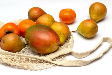  Fruits lie in a textile eco-friendly grid on a white table.