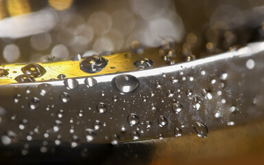 Extreme close up shot of water droplets on lady 's stainless steel bracelet.