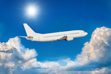 Fototapeta na wymiar White passenger jet plane fly in the air above picturesque clouds