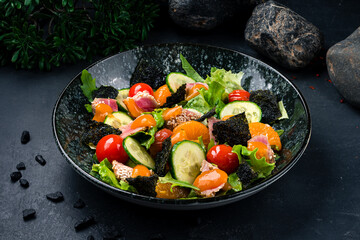 Fresh salad with tuna, lettuce, tomatoes, cucumbers, arugula, nori, tangerines, sesame and mango sauce.