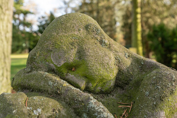 Der Trauernde aus Stein mit Moos bewachsen auf einem Friedhof in Osnabrück