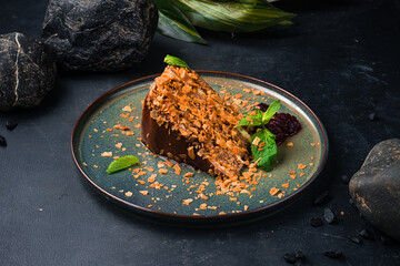 Piece of fresh chocolate cake with jam and mint on a plate.