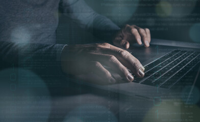 Hands typing on laptop keyboard. Man working on computer. Dark mood. Technology, business concept