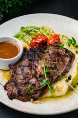 Fresh Ribeye beef steak with mashed potatoes and sauce, closeup.