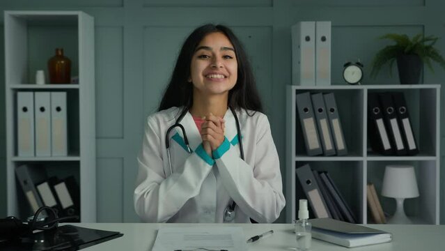 Happy young woman doctor medic looking at camera use virtual video connection consulting patient online share news congratulating good health test results give support clapping hands ovation gesture