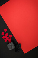 Red and black background with a box with a geometric pattern, the background is decorated with hearts
