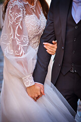 The bride holds the groom's hand with both hands. Wedding theme.