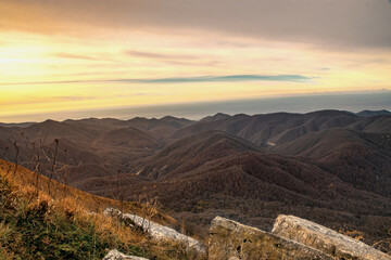 View at dawn from the top of Mount Peus in the North-Western Caucasus. View from a height of 1000 m on the mountain peaks of the Black Sea coast of the Caucasus.