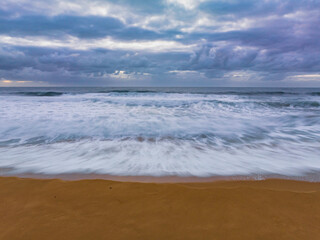 Sunrise and a cloud covered sky at the beach
