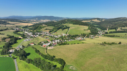 Fototapeta na wymiar Pastures mountain horses cattle, cows sheep and goats, the ruins of the Brnicko castle village forest wood pasture Jeseniky view summer drone aerial Brnicko houses graze grass scenery cottage