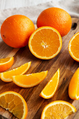 Raw Organic Orange Fruit on a white wooden background, side view.