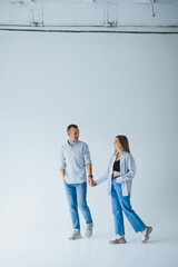 Young happy couple in love in jeans and shirts on a white background. Smiling romantic man and woman.