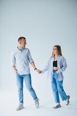 Young happy couple in love in jeans and shirts on a white background. Smiling romantic man and woman.