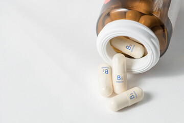 Vitamin B3. Vitamins in capsules. White capsules with vitamin B3, niacinamide or nicotinic acid are...