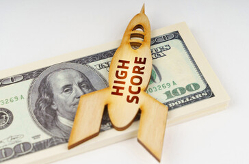 On the dollars lies a wooden model of a rocket with the inscription - High Score