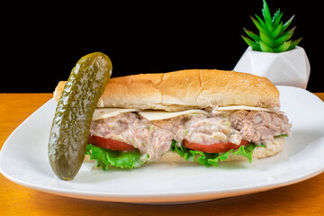 tuna fish salad sub  with a pickle