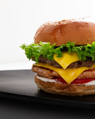 Mix Burger With Cheese on a black plate with white background