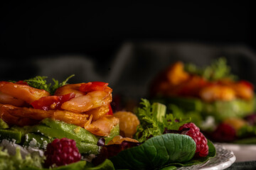 Smoked shrimp salad with lettuce greens, grape tomatoes, and yellow and red raspberries.