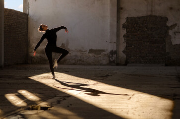 	
Ballerina dancing in an abandoned building on a sunny day