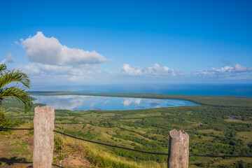 View of the coastline of the Atlantic Ocean on the island of Haiti. Green coastline turns into ocean. View from the mountain to the green valley next to the ocean. Dominican Republic