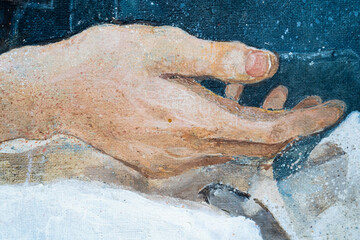 A young man with curly hair holds a handkerchief in his hand. The young man lies on a pillow....