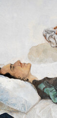 A young man with curly hair holds a handkerchief in his hand. The young man lies on a pillow....
