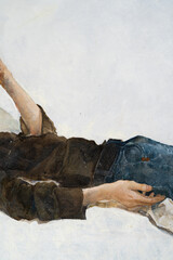 A young man with curly hair holds a handkerchief in his hand. The young man lies on a pillow....