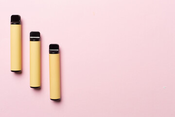 Disposable electronic cigarettes on color background, top view