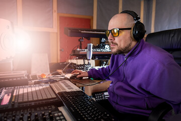 Music producer working in sound recording studio. Sound engineer sitting at mixing console panel. Creating music concept