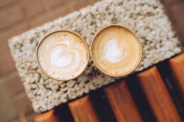 Two paper cups of cappuccino with latte art