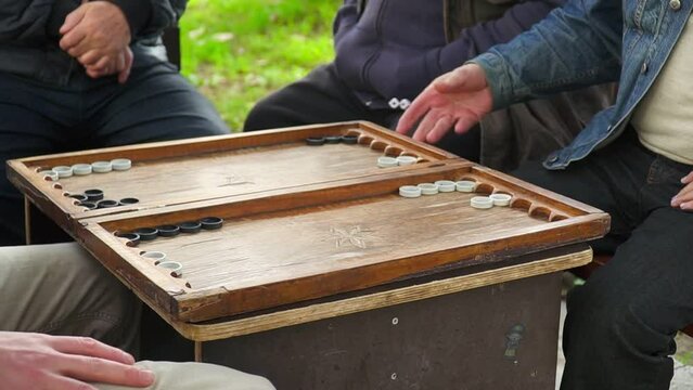  men playing backgammon sitting at the table. High quality FullHD footage