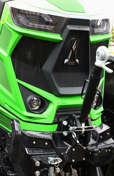 Front mask of modern German agricultural open field tractor Deutz Fahr Agrotron 7250 TTV with part of front electro hydraulic PTO system and LED headlights visible. Displayed on agro expo in Nitra.
