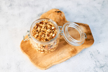 Obraz na płótnie Canvas Homemade granola with nuts with a glass jar on a wooden board