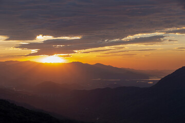 Fototapeta premium Sun rising over the clouds, in the hills. Immigrants highway, Santos, Sao Paulo state, Brazil