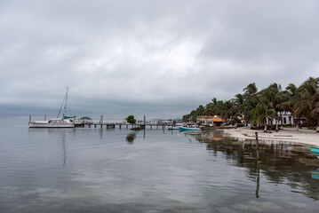 Fototapeta na wymiar Caye Caulker Island in Caribbean Sea. Cloudy Morning And Calm Water in Pier. Belize. Caribbean Island