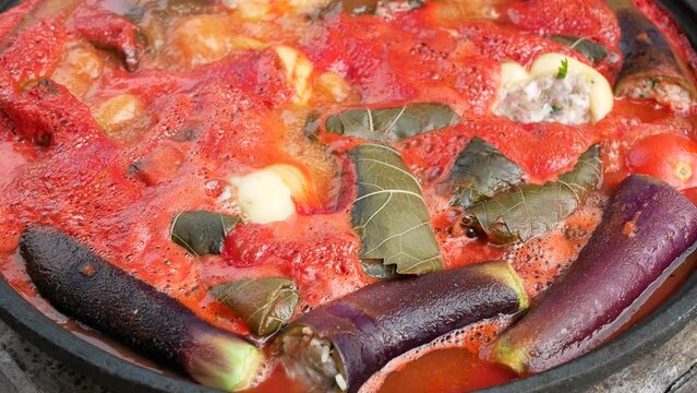 Stuffed vegetables cooking: liquid is bubbling and evaporating, close up. Classical Turkish, Azerbaijani or Armenian cuisine