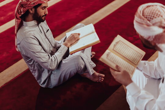 A group of Muslims reading the holy book of the Quran in a modern mosque during the Muslim holiday of Ramadan