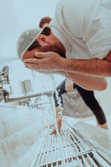 A Muslim performing ablution. Ritual religious cleansing of Muslims before performing prayer. The...