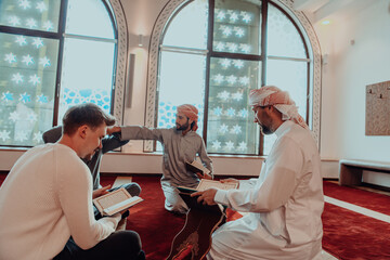 Obraz premium A group of Muslims reading the holy book of the Quran in a modern mosque during the Muslim holiday of Ramadan