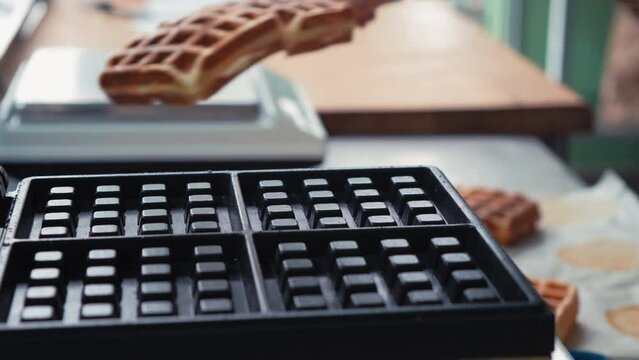 Close-up chef pours waffle batter in a waffle iron in a professional kitchen. Waffle making at the hotel with all-inclusive meals. belgian waffles in a waffle iron