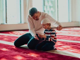 Father and son in mosque praying and reading holly book quran together islamic education concept