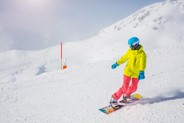 Girl snowboarder enjoys the winter ski resort. - 557289713