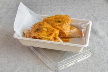 A pair of delicious juicy tortilla skewers with bread in a home delivery container