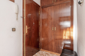 Hall of a house with armored door and built-in wardrobe with varnished sapele wood to match